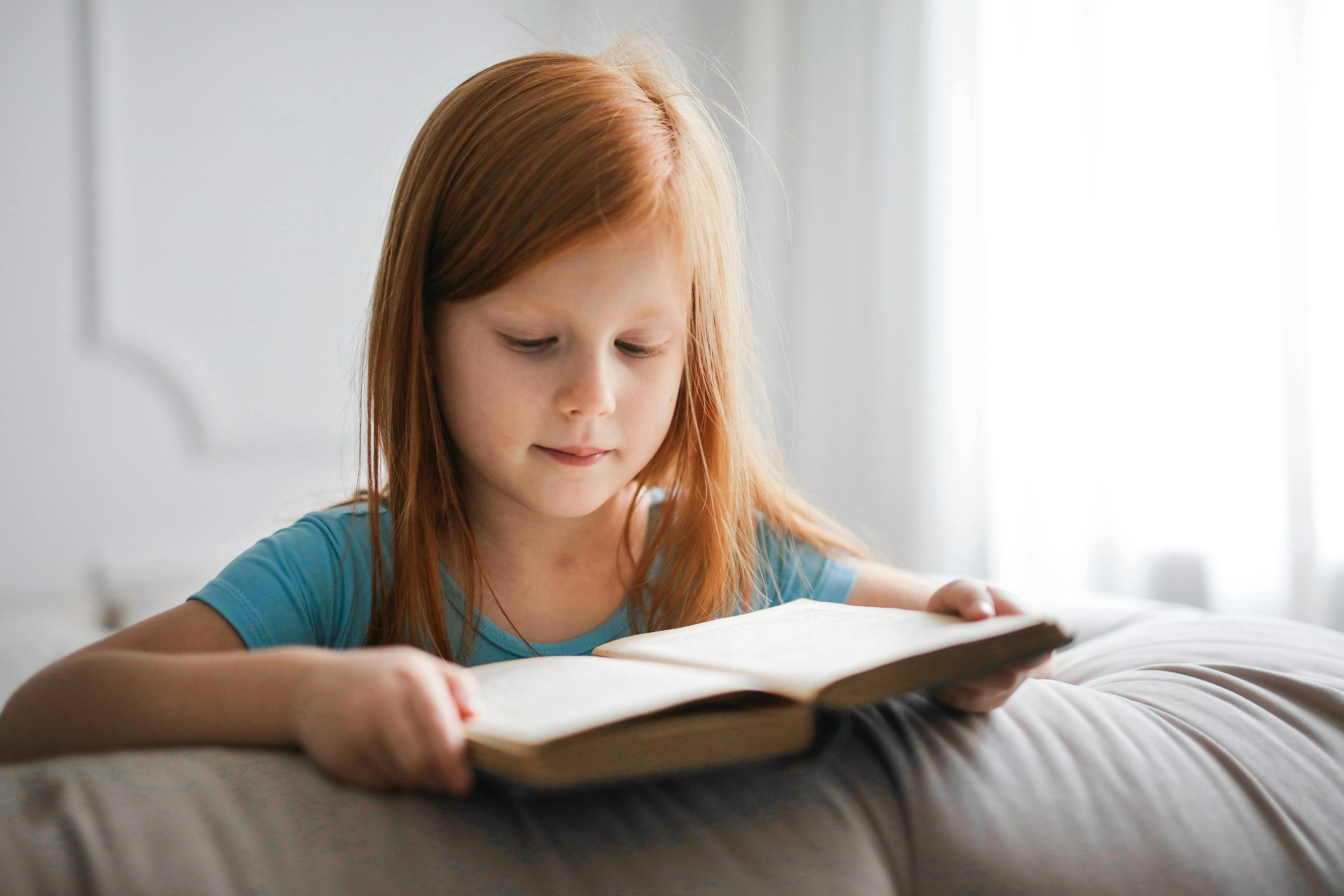 Niña pequeña leyendo un libro con concentración — la dislexia requiere instrucción de lectura estructurada, no solo más tiempo
