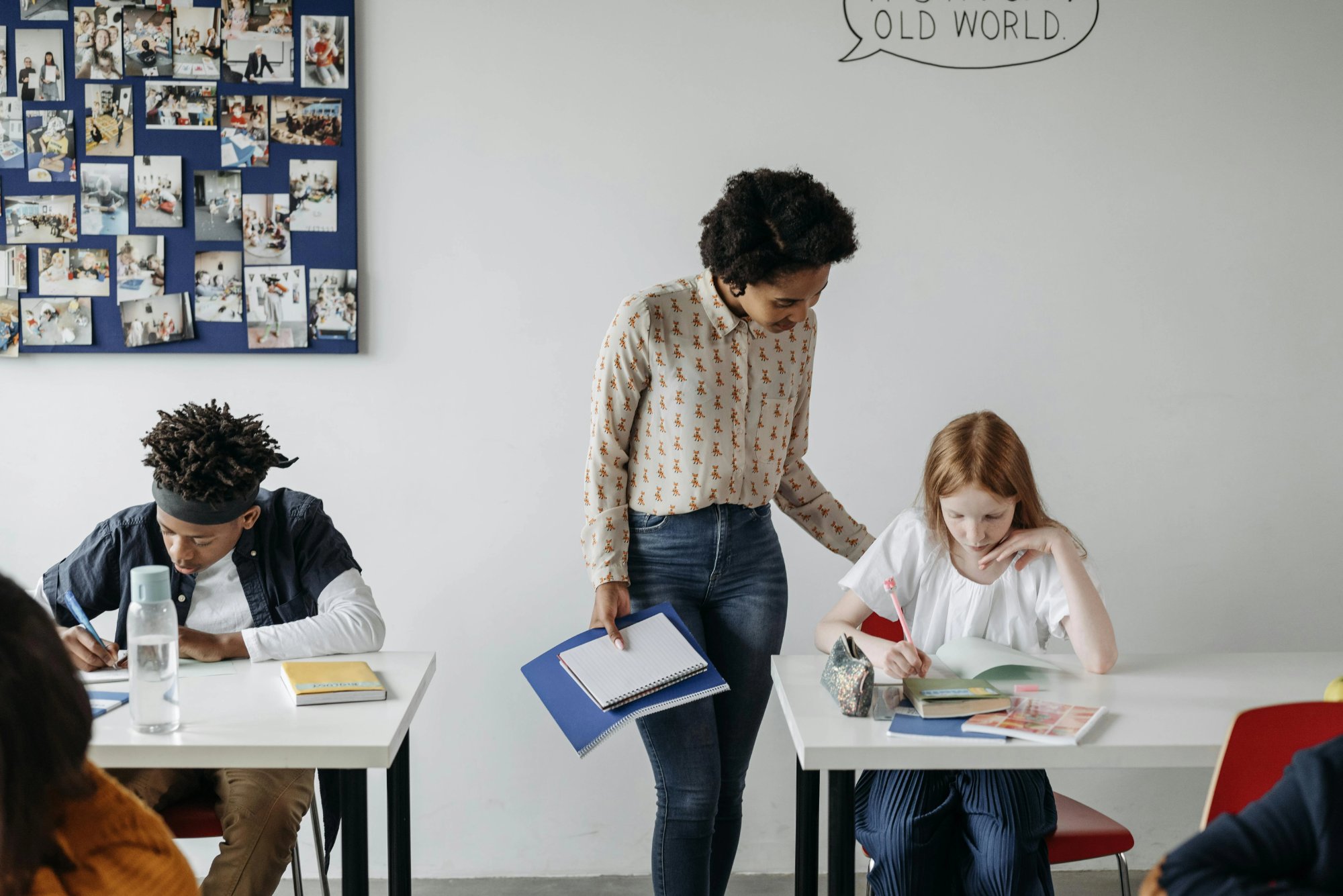 Teacher walking between desks supporting students in an inclusive classroom — illustrating IEP accommodations and modifications in practice