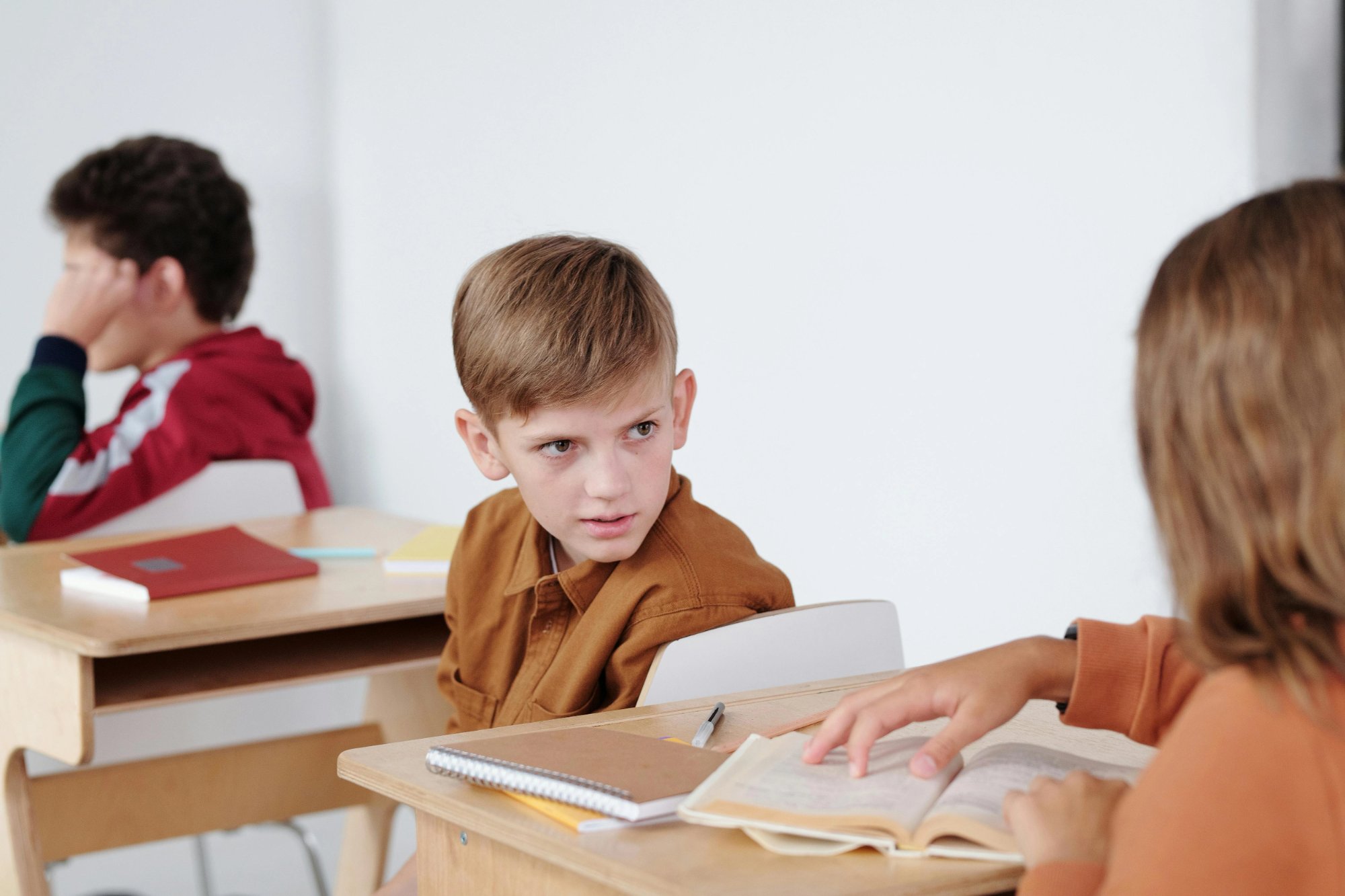 Niño en clase con expresión de tensión y ansiedad — la ansiedad afecta significativamente el rendimiento educativo
