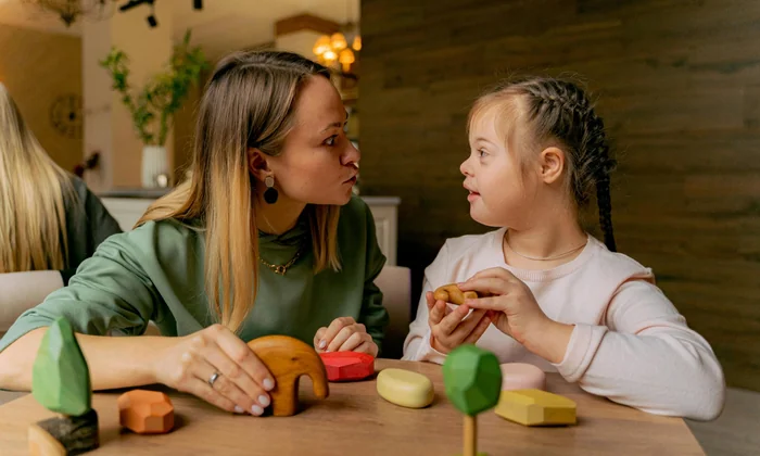 Child with disability supported by teacher in inclusive classroom