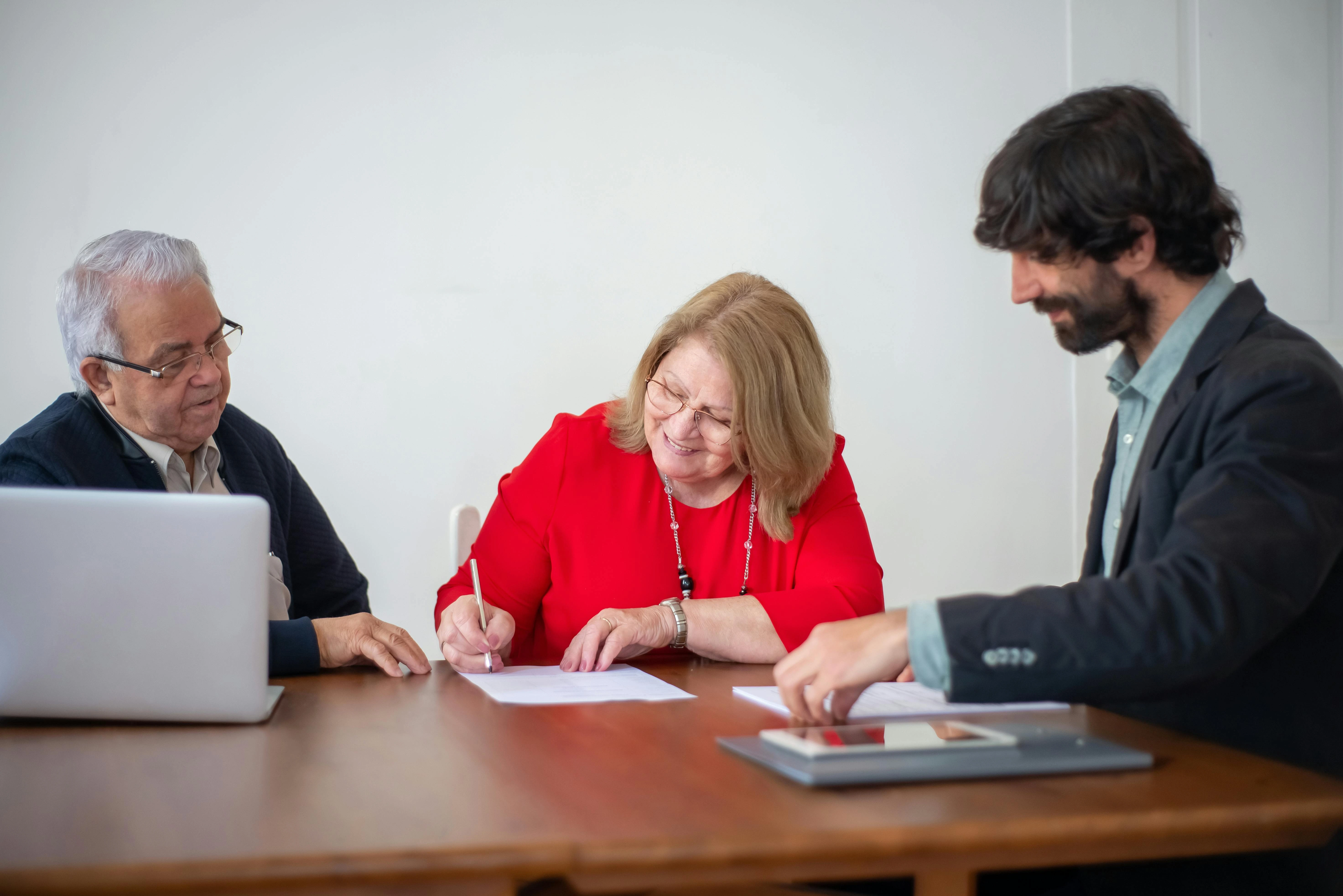 Padres en una mesa de reunión IEP con un profesional escolar, revisando documentos