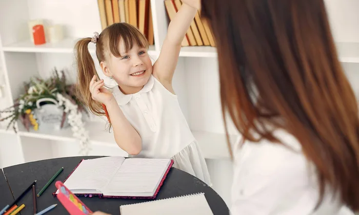 Young girl in speech therapy session with adult
