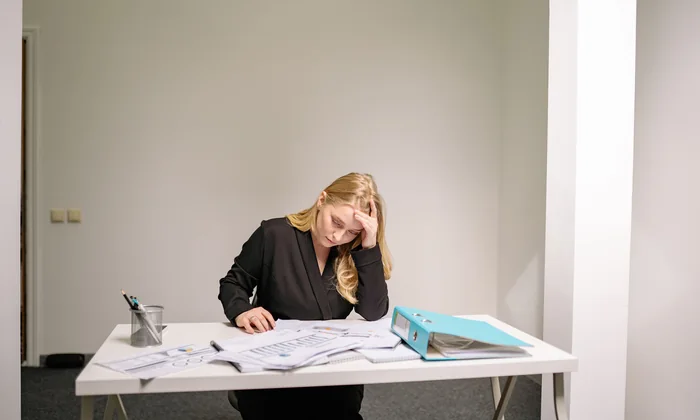 A parent sitting at a table covered in documents, weighing up which dispute route to take